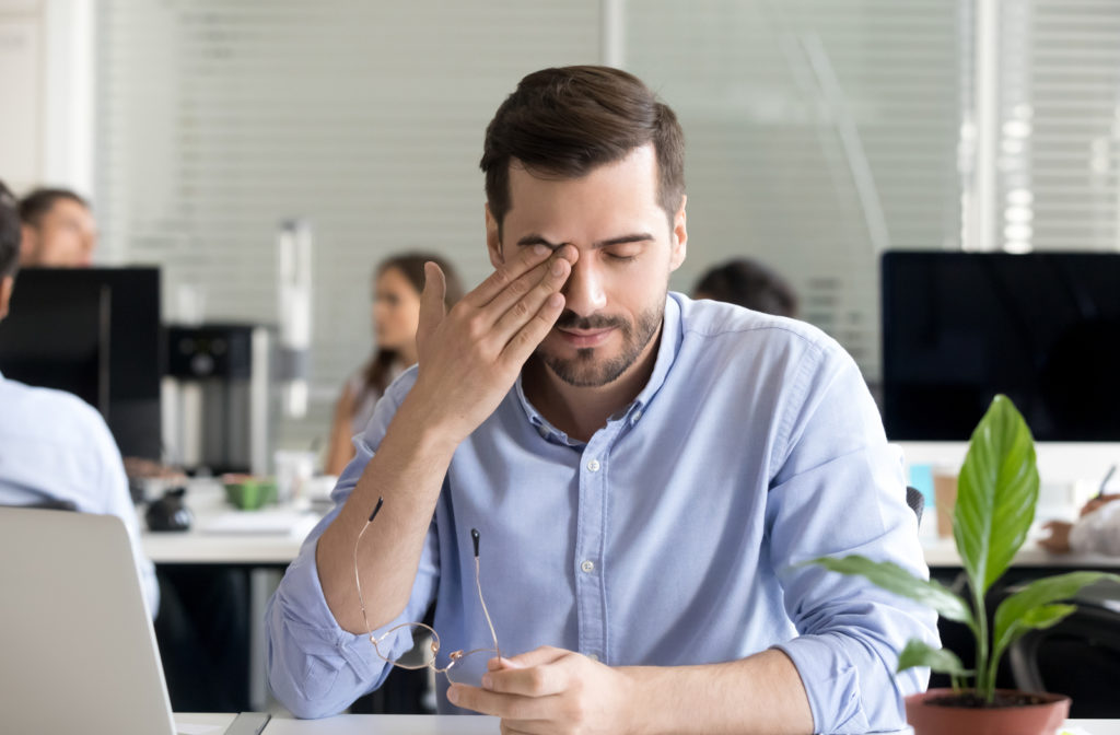 Man rubbing his dry eyes.