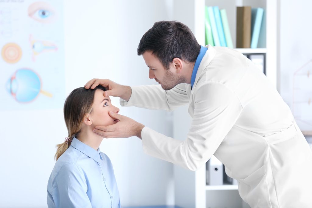 Doctor checking out eyes of patient.