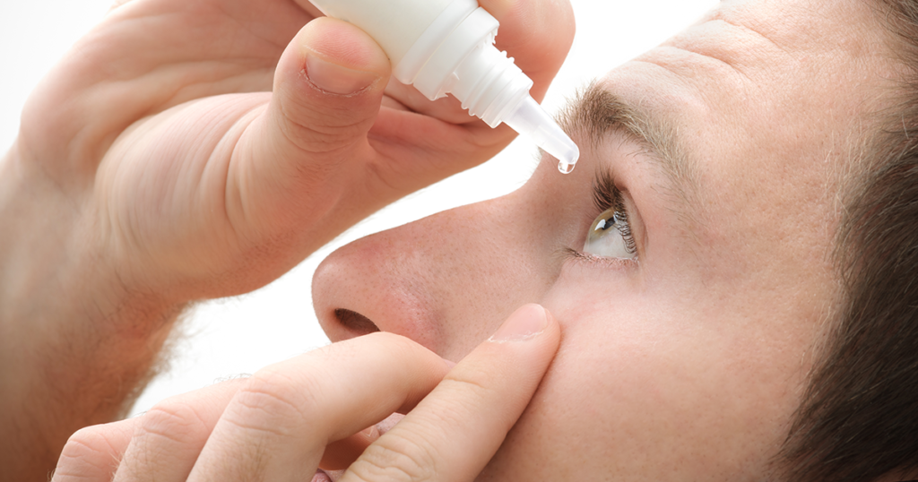 Man puts eye drops into his eyes