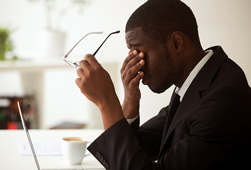 Man removing his glasses and rubbing his dry eyes