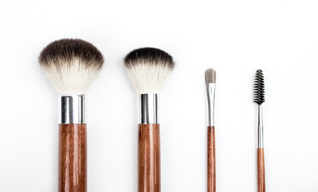 Different size cosmetic brushes set on a white background.
