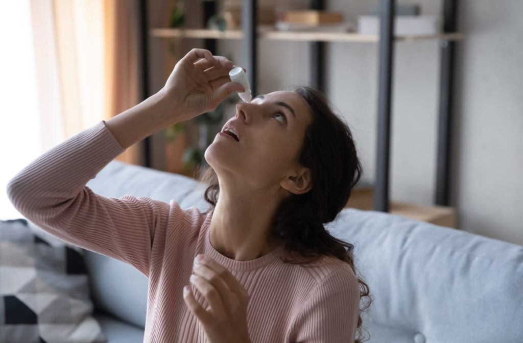 A young woman uses eye drops to relieve the symptoms of dry eye disease. 