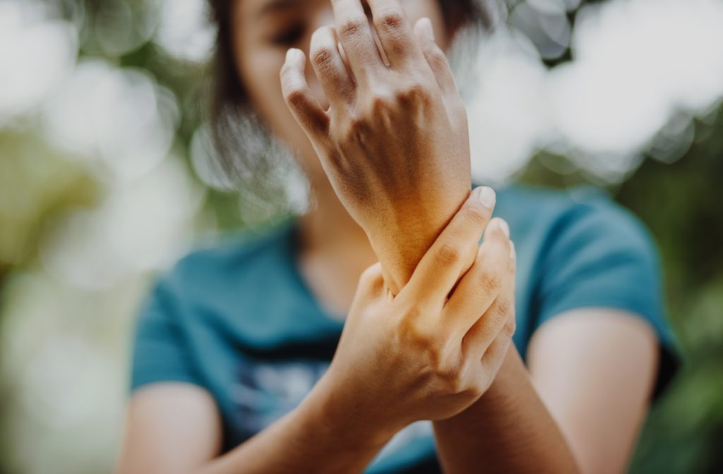 Young woman with pain in her left wrist due to rheumatoid arthritis