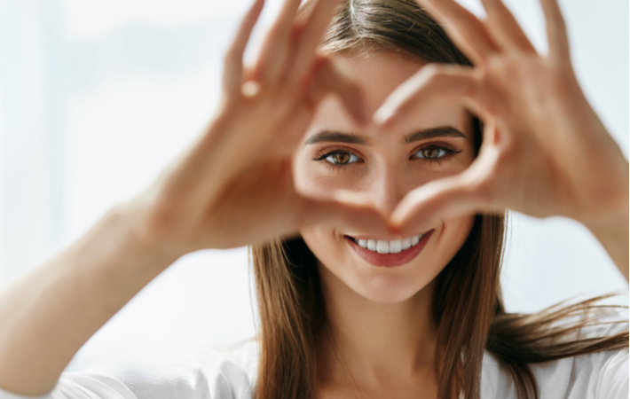 Women drawing heart around eyes to portray healthy vision