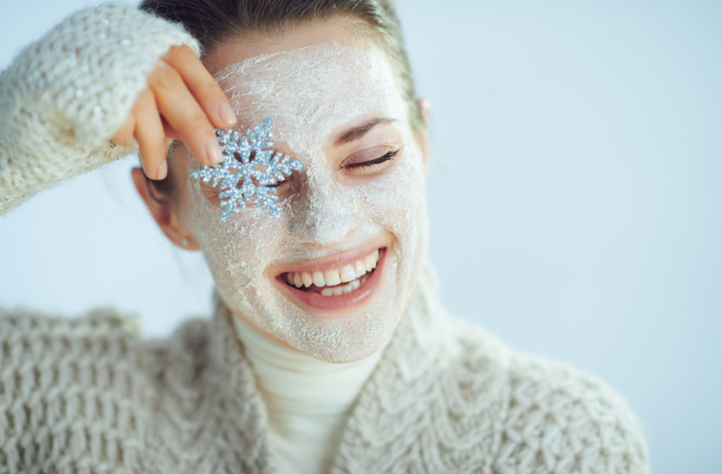 Women with snowflake in front of eyes to display healthy vision without dry eye with face mask on.
