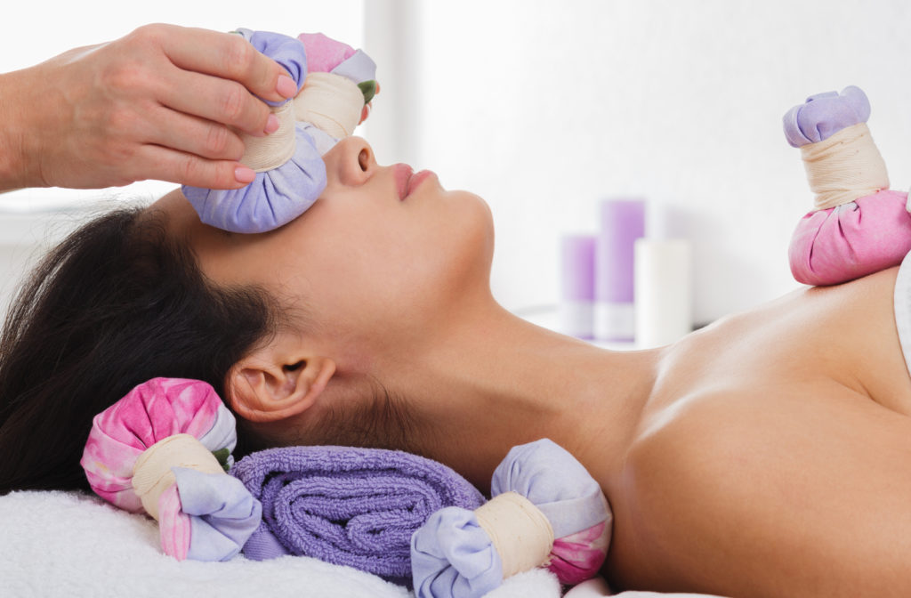 Women laying down and having warm compress over eyes tp help with dry eye