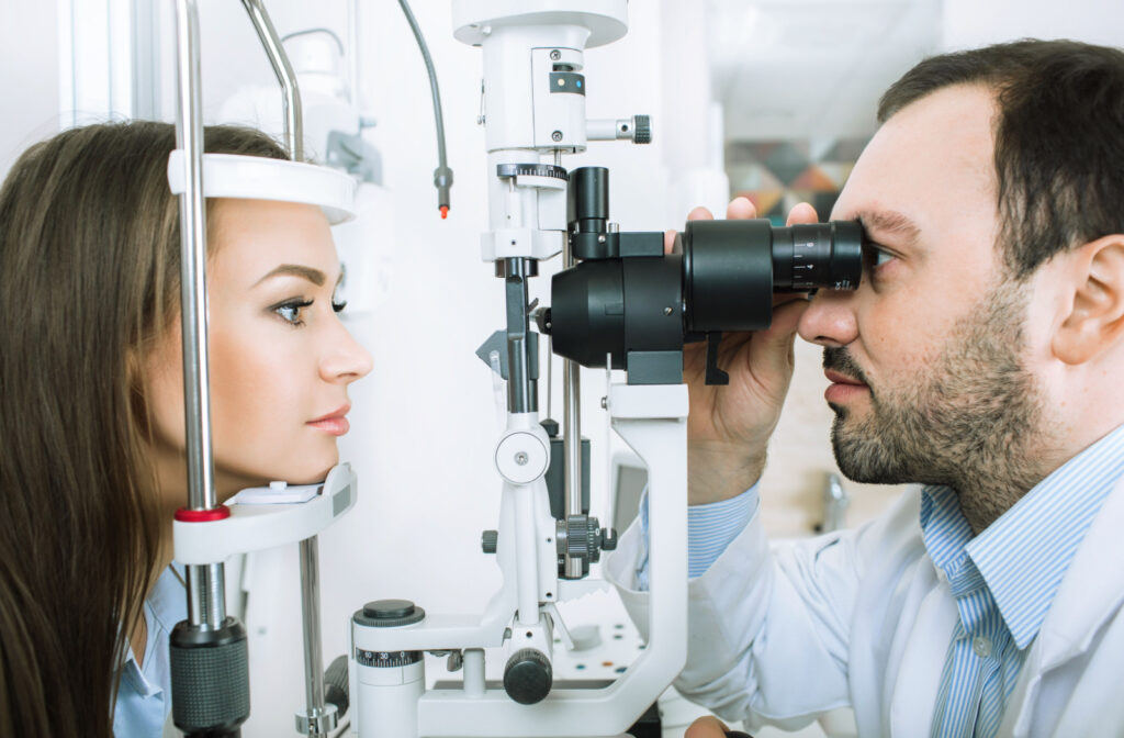 A male optometrist examining the eyes of a woman using a medical device to detect potential eye problems.