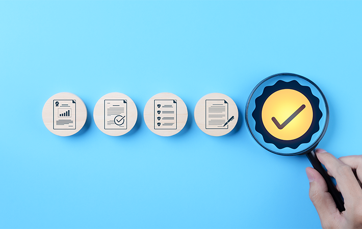 Sky blue background with 4 icons depicting paper work, and a 5th icon with a golden checkmark.
